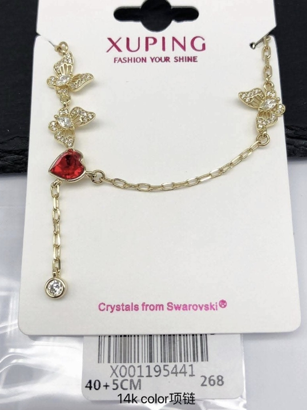 Butterfly necklace with a red crystal heart.